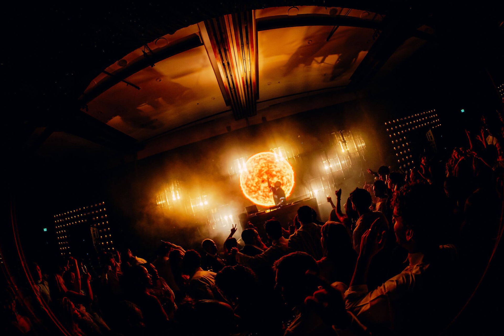 DJ con visual de sol ardiente en pantalla LED